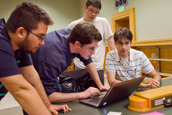 Students huddle to strategize at the HackFSM launch event.  