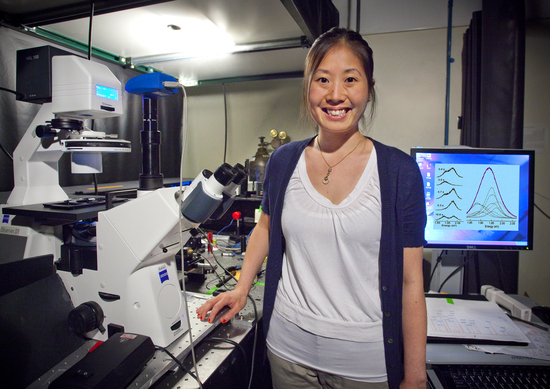Choi stands next to a large microscope and computer.