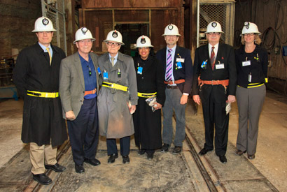 Seven people in hard hats in an underground cavern.