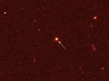 A faraway image with an arrow poiting to a galaxy.