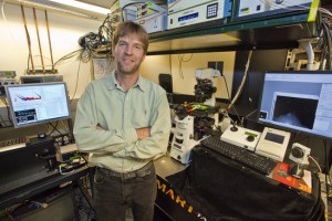 Groves stands in front of a system of computers and lithographers.