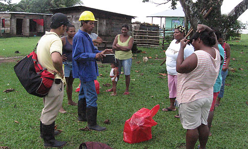 A man in a hard hat explains something to a group.