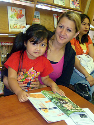A mom and her daughter read a book.