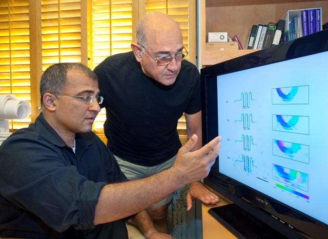 Two men look at a screen of various diagrams.
