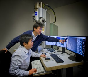 Researchers examine a computer model.