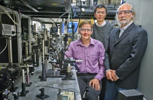 Three researchers stand in a room full of spectroscopes.