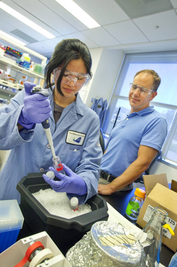 Two researchers using micropipettes.