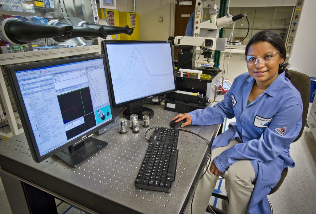 A researcher sits at a computer in a lab.