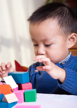 A young boy playing with building blocks.