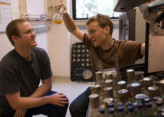 Two researchers discuss a culture in a lab.