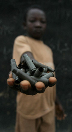 An African child shows a handful of bullet casings.