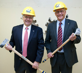 Two men with hammers and helmets.