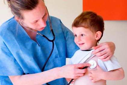 A nurse uses a stethoscope on a toddler.