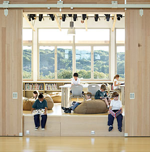 Chartwell School students read and relax in a library/stage/study area.