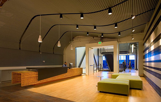 A modern room with curvy wood ceilings and green accents.