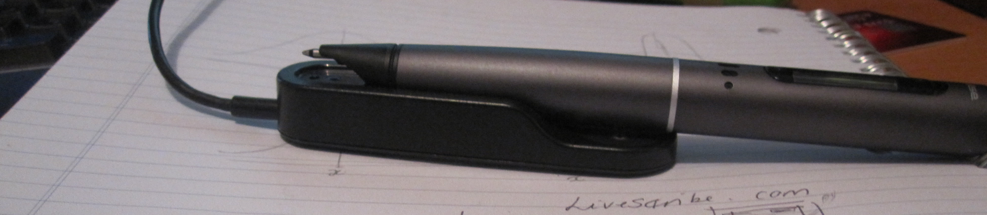 The pen charges on a small black block.