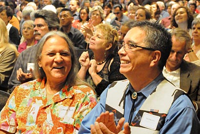 Neconie and Myers clap in a large audience.