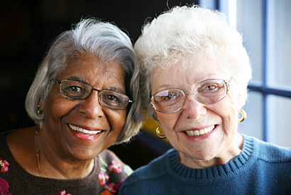 Two older women smile together.