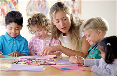 Stock photo of a woman teaching four young students.