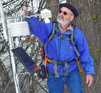 Steven Glaser examines a contraption in the woods after a snow.