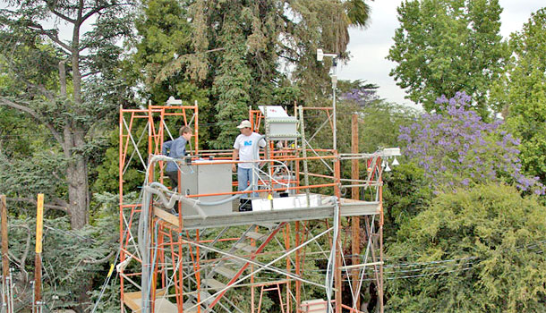 Two researchers stand on a tower to survey.