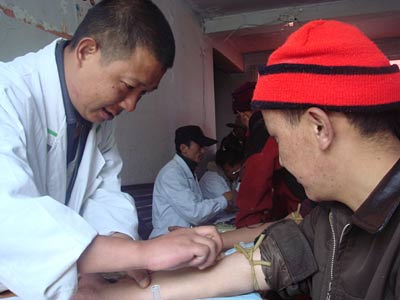 A Chinese researcher collects a blood sample from an ethnic Tibetan man participating in the DNA study. Photot: Beijing Genomics Institute