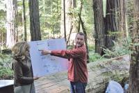An instructor lectures amidst a redwood forest.