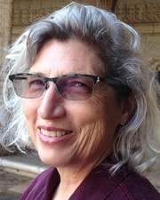 Image of Linda Rugg, woman with white hair and pale skin, glasses, smiling