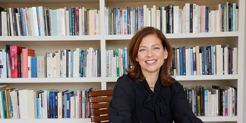 Dean Sara Guyer sitting in library setting.