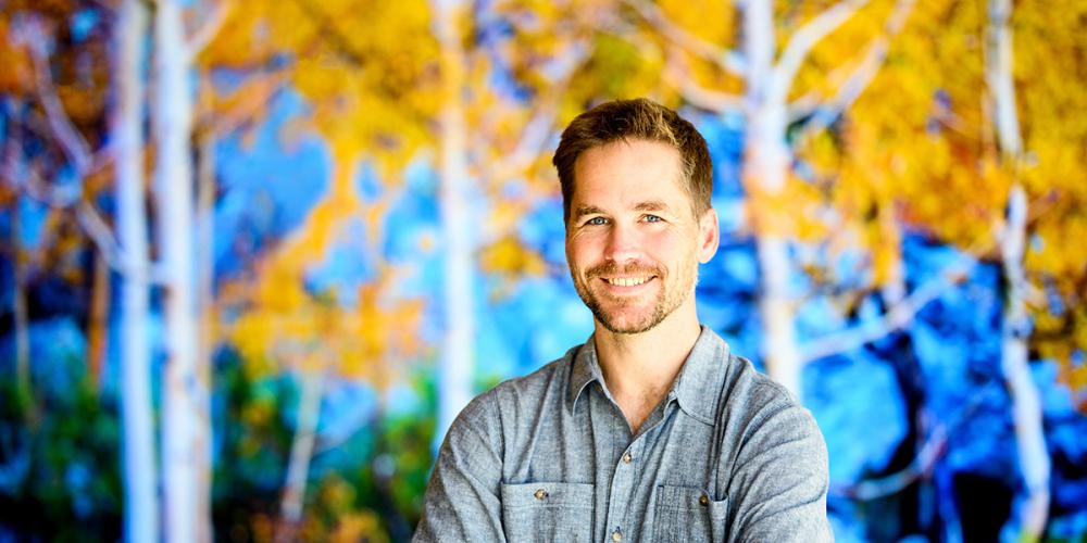 Reed Walker with arms crossed and natural background setting