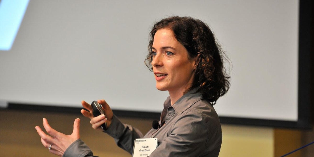 Gabriel Gann presenting with hands raise in front of her