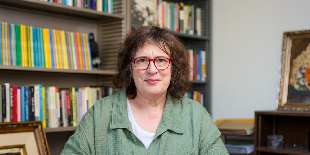 Kate O'Neill sitting in her office in front of a bookshelf