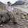Professor Kurt Cuffey leaning against a boulder at a remote mountain location in Patagonia.