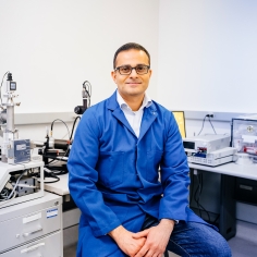Ali Javey sitting in lab with equipment in background