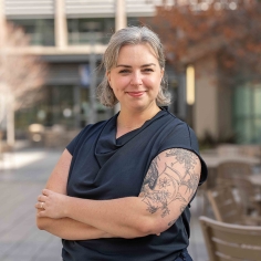 Olivia Natan standing with arms crossed in outdoor setting