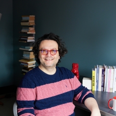 Mario Telò at a desk with books in the background