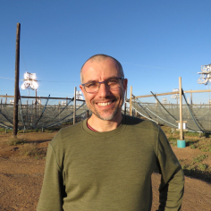 a photo of Aaron Parsons standing in front of the HERA telescope in South Africa in 2025