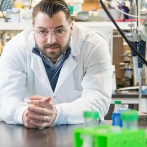 Person leaning over bench in lab