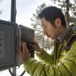 Man looking at sensor control panel in snowy area.