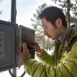 Man looking at equipment in snowy area