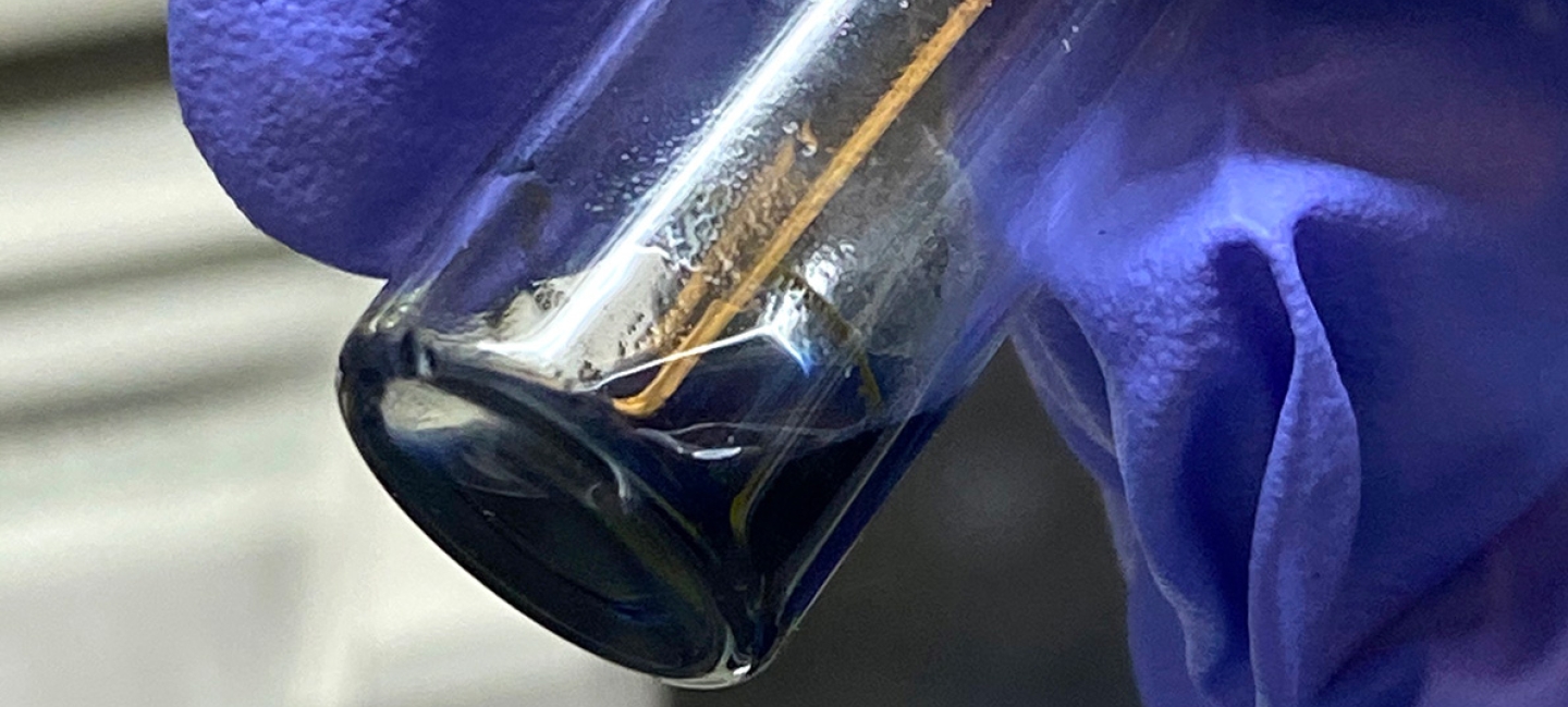 The purple/blue solution in this vial contains crystals of the berkelocene “sandwich.” 