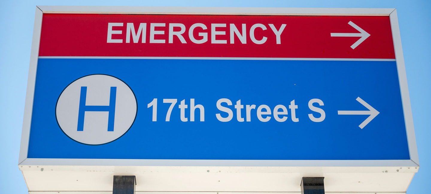 a sign outside of a hospital pointing to the Emergency Room