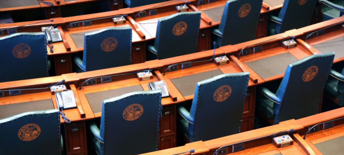 arcing rows of empty chairs in a legislative chamber