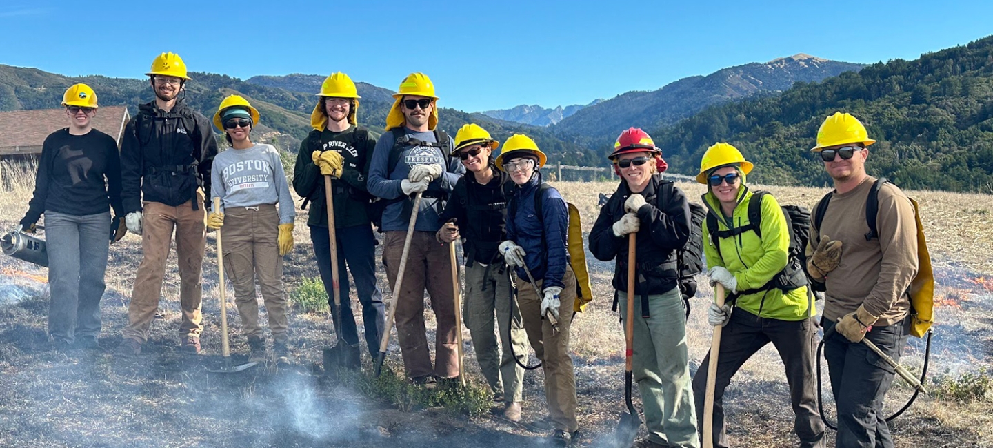 Americorps workers in hardhats posing outdoors