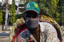 A rickshaw driver in Dhaka, Bangladesh, wears a mask to protect against transmission of the COVID-19 virus.