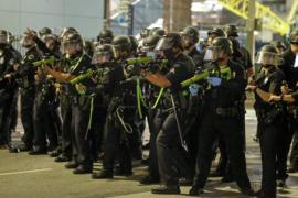 A line of police officers in riot gear point weapons containing rubber bullets at protesters in Los Angeles following the death of George Floyd, a black man who was killed in police custody on May 25.