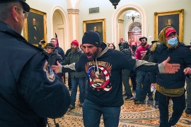 One of the militants who broke into the US Capitol gestures toward police officer