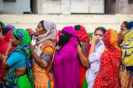 women in Bangladesh in a crowded line await COVID-relief aid