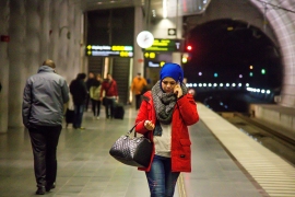woman walking and talking on a phone at a subway station at night