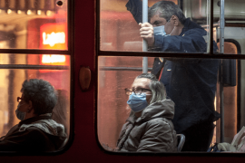 People riding public transportation wearing masks